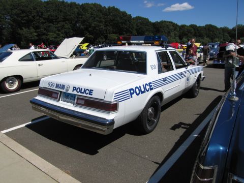 1991 Ford LTD Crown Victoria - Rear view of a white Miami Police Dodge Diplomat cruiser, unit 839, with POLICE lettering and blue stripes.