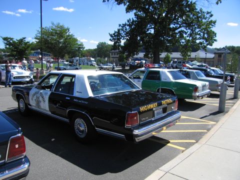 1991 Ford LTD Crown Victoria - Rear quarter view of a black-and-white Highway Patrol Ford sedan parked at an outdoor car show.