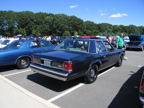 1991 Ford LTD Crown Victoria - Rear three-quarter view of a dark blue Ford LTD Crown Victoria sedan parked in a packed car-show lot.