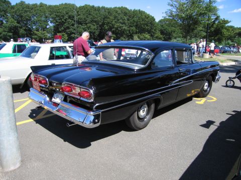 1991 Ford LTD Crown Victoria - Rear three-quarter view of a black late-1950s Ford sedan with dual round taillights at a car show.
