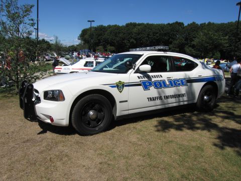 1991 Ford LTD Crown Victoria - Side view of a white North Haven Police Dodge Charger traffic-enforcement cruiser parked on grass.