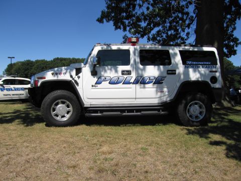 1991 Ford LTD Crown Victoria - Side view of a white North Haven Police Hummer H2 DUI enforcement vehicle with roof light, on grass.