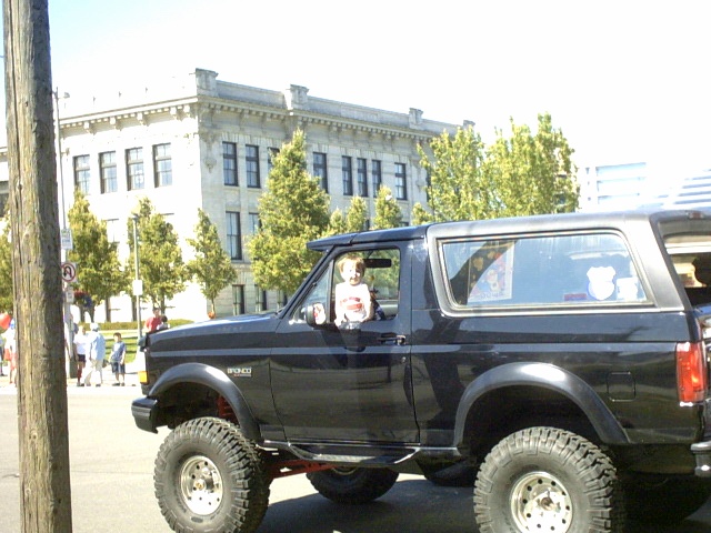 Dark lifted two-door Ford Bronco SUV shown in side profile on street