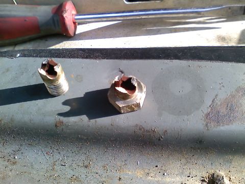 1990 Ford Bronco - Stripped bolt and nut removed with a screwdriver, likely from a vehicle repair.