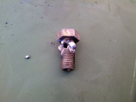 1990 Ford Bronco - A close-up of a damaged metal bolt with visible thread damage and a broken head.