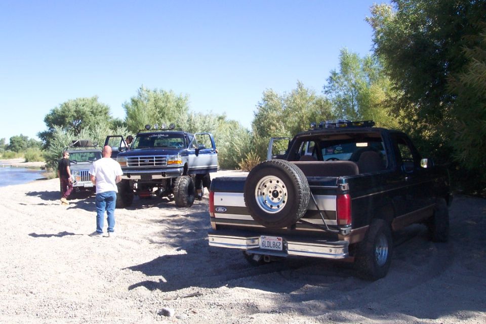 Black Ford Bronco rear view with spare tire mounted on the back, lifted suspension, and roof rack