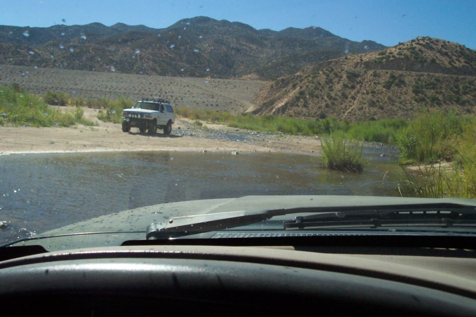 White 1995 Ford Bronco crossing stream