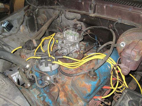 1979 Ford Bronco - Close-up view of a vehicle's engine bay, showing the carburetor and ignition system components.