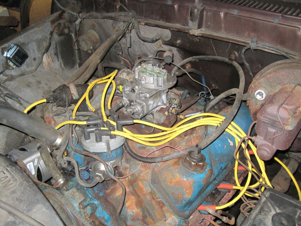 Engine bay with carburetor, distributor, and yellow spark plug wires