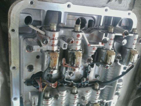 1995 Ford Bronco - Close-up view of a transmission valve body, showing solenoids and electrical connections.