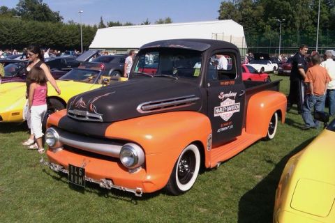 1991 Ford Crown Victoria - A vintage Ford pickup truck, customized with Harley-Davidson branding, is displayed at an outdoor event with other vehicles.