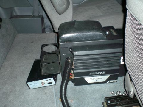 1996 Ford Bronco - Interior floor-mounted center console in gray cloth trim with an Alpine V-Power 550W amplifier mounted to its side, wiring in black split l…
