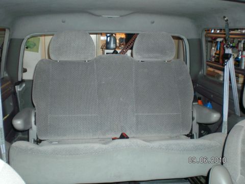 1996 Ford Bronco - Gray cloth rear bench seat with two headrests and a red seatbelt buckle, viewed from behind through the vehicle's rear opening with the tai…