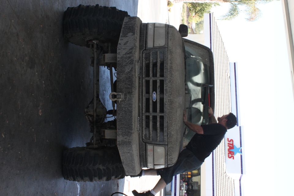 1992 Ford Bronco front view, covered in mud, with large off-road tires