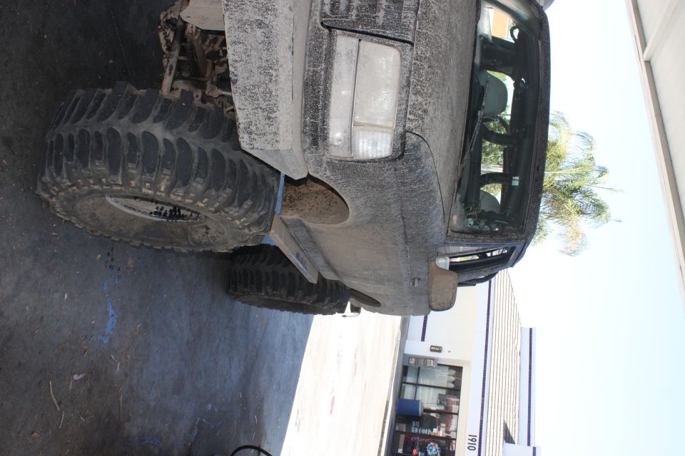 1992 Ford Bronco covered in mud, large off-road tires visible
