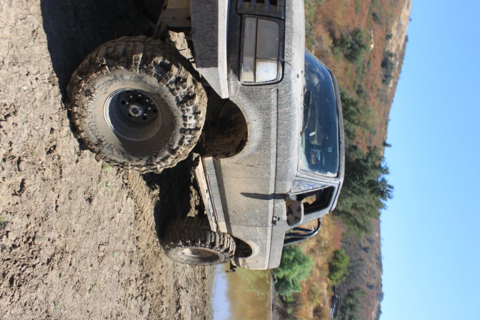 1992 Ford Bronco 3q-front view, covered in mud, on a dirt trail
