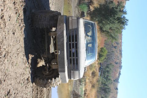 1992 Ford Bronco - A 1992 Ford Bronco sits in muddy terrain, equipped with a heavy-duty bumper and off-road tires.