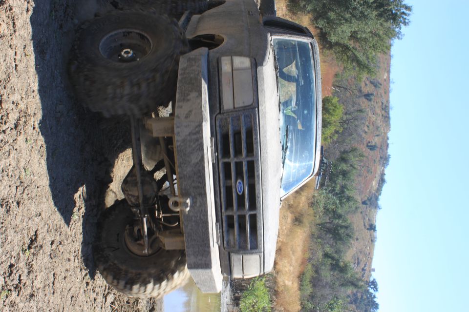 1992 Ford Bronco front view, mud on body, large tires, off-road