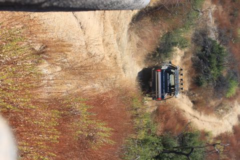 1992 Ford Bronco - An SUV navigates a narrow, winding dirt path through dry vegetation and trees.