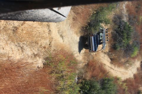 1992 Ford Bronco - A dark SUV navigates a dusty trail surrounded by dry vegetation.