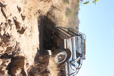1992 Ford Bronco - An off-road vehicle is stuck in a narrow dirt ravine on a sunny day.