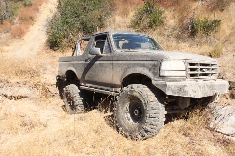 1992 Ford Bronco - This heavily modified 1992 Ford Bronco navigates a challenging off-road trail.