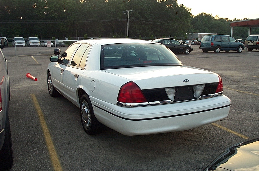 White 2001 Ford Crown Victoria sedan, rear 3/4 view, parked in lot