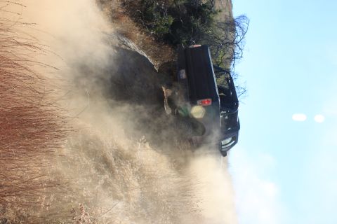 1992 Ford Bronco - A black 1992 Ford Bronco navigates a dusty trail, kicking up a cloud of dirt.