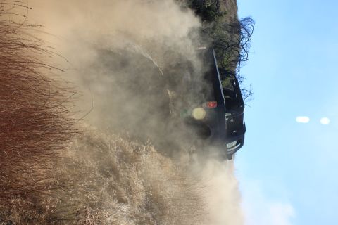 1992 Ford Bronco - SUV driving off-road and creating a dust cloud.
