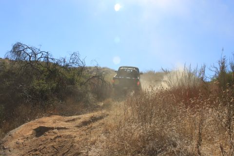 1992 Ford Bronco - Off-road vehicle ascends a dusty trail on a sunny day.