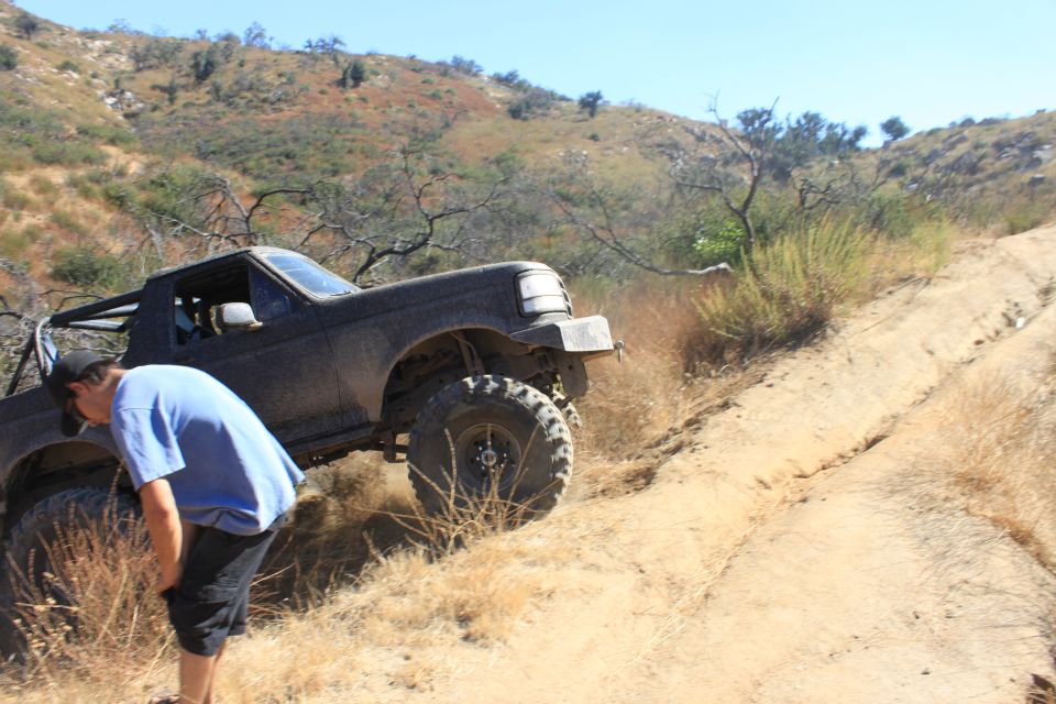 1992 Ford Bronco 3q-front view on a dirt trail with a person nearby