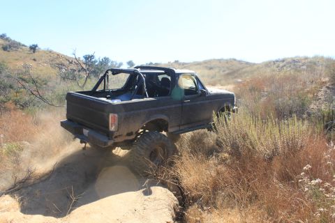 1992 Ford Bronco - This 1992 Ford Bronco navigates a challenging off-road trail, kicking up dust as it goes.