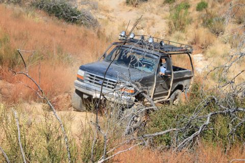 1992 Ford Bronco - This 1992 Ford Bronco navigates a off-road trail, equipped with a roof rack and auxiliary lighting.