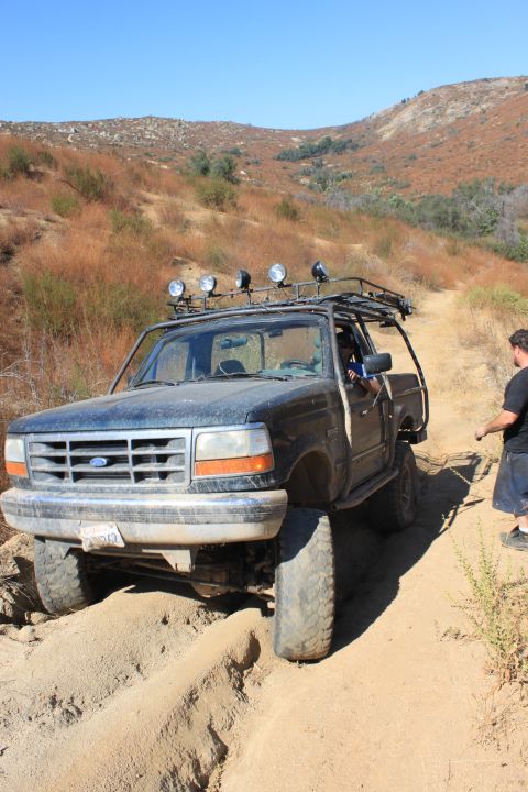 1992 Ford Bronco - This 1992 Ford Bronco is tackling a challenging off-road trail in a dry, hilly landscape.