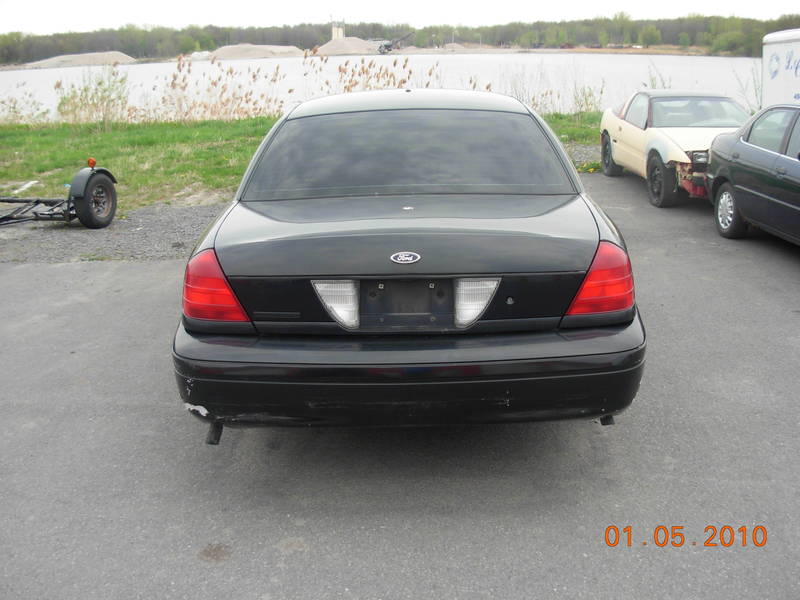 Black 2000 Ford Crown Victoria rear view. Other vehicles visible
