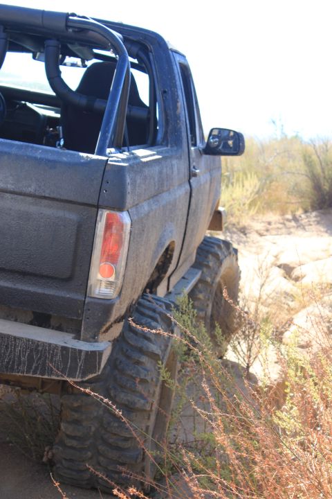 1992 Ford Bronco - Modified 1992 Ford Bronco with roll cage and oversized tires navigates a rocky off-road trail.