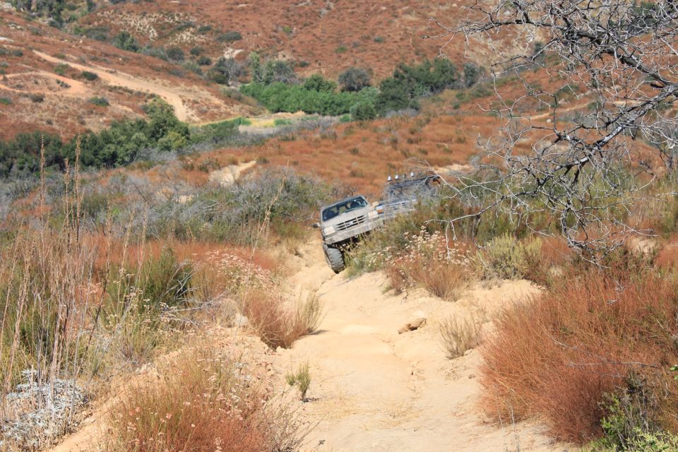 1992 Ford Bronco driving off-road on a dusty trail