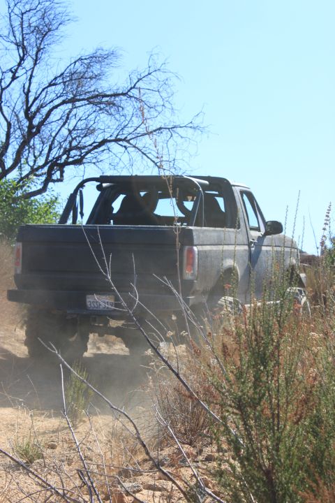 1992 Ford Bronco - A 1992 Ford Bronco kicks up dust as it navigates a rough, outdoor trail.