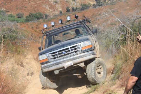 1992 Ford Bronco - Off-road adventure in a 1992 Ford Bronco on a dusty, hilly terrain.