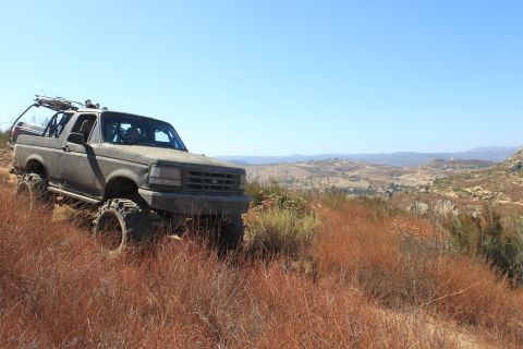 1992 Ford Bronco - This 1992 Ford Bronco is shown navigating a , dry terrain with its large off-road tires.