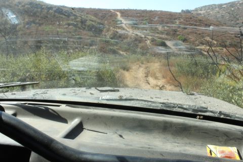 1992 Ford Bronco - Driving through a dry, brush-covered landscape on a dirt track, with another vehicle visible on the distant hillside.