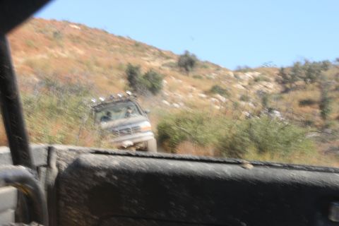 1992 Ford Bronco - A 1992 Ford Bronco navigates a , dusty trail under a clear blue sky.