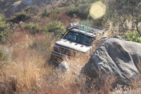1992 Ford Bronco - 1992 Ford Bronco navigating a rocky, off-road trail.