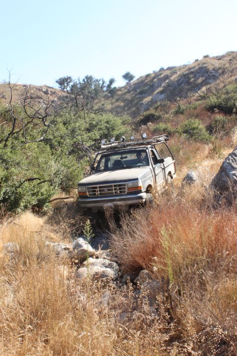 1992 Ford Bronco - This 1992 Ford Bronco is shown off-roading on a dry, rocky hill under a clear blue sky.
