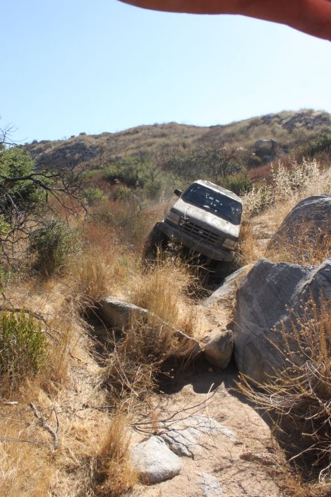 1992 Ford Bronco - A vehicle navigates a challenging off-road trail with steep inclines and large rocks.