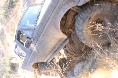 1992 Ford Bronco - This 1992 Ford Bronco is captured in a three-quarter front view, navigating a rocky, off-road environment.
