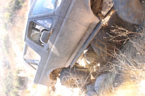 1992 Ford Bronco - This vehicle appears to be an older model SUV, possibly modified for off-road use, situated in a dry, brushy environment.
