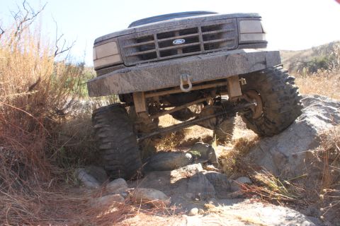 1992 Ford Bronco - This Ford truck is shown off-roading over rocks and dirt.