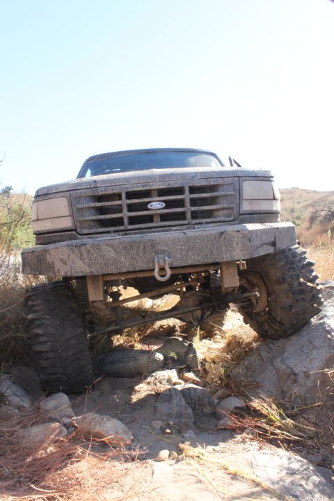 1992 Ford Bronco - This 1992 Ford Bronco navigates a challenging rocky trail, its body caked in mud.