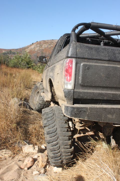 1992 Ford Bronco - This 1992 Ford Bronco is navigating a challenging off-road trail with steep inclines and rocky terrain.
